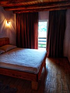 a bedroom with a bed and a window at Zorra Challet in Eşelniţa