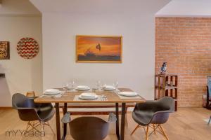 a dining room with a wooden table and chairs at Private Balcony Infinity Pool & Rooftop in La Roma - Queretaro in Mexico City