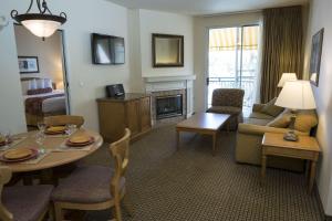 uma sala de estar com uma mesa e uma sala de estar com um sofá e uma lareira em Suites at Club De Soleil Las Vegas em Las Vegas