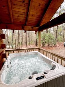 Tellico Plains的住宿－Romantic Laurel Wood Home with Private Hot Tub，小屋后门廊上的热水浴池