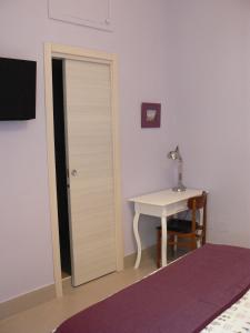 a room with a door and a table with a lamp at Cerasella B&B in Naples