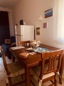 cocina con mesa de madera con sillas y nevera en casa di Golfo Aranci mare en Golfo Aranci