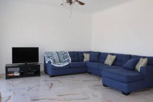 um sofá azul numa sala de estar com uma televisão em Hacienda Bay 4 bedrooms Chalet em El Alamein
