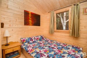 łóżko w drewnianym domku z oknem w obiekcie Mazurskisen w mieście Mrągowo