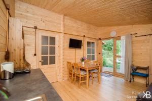 drewniany pokój z drewnianym stołem i telewizorem w obiekcie Mazurskisen w mieście Mrągowo