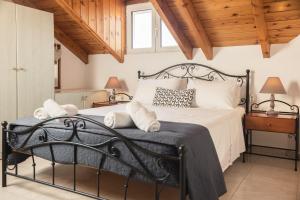 a bedroom with a black bed with white sheets and pillows at George Beachfront Apartments in Lithakia