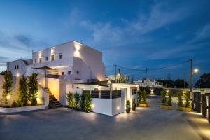 a white house with a courtyard at night at Potamida Suites in Vóthon