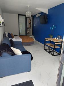 um quarto com uma cama e uma parede azul em L'hacienda de Maria montchanin em Montchanin