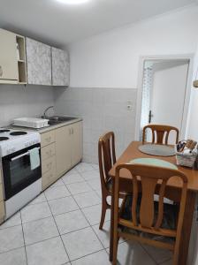 Paxos Dream House في Vlachopoulátika: مطبخ مع طاولة وغرفة طعام