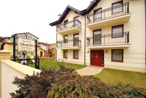 un gran edificio blanco con una puerta roja en Amelia Apartamenty - sala zabaw, garaż podziemny, en Władysławowo