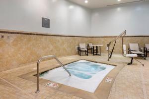 a hot tub in a room with chairs and a table at Cambria Hotel Rockville in Rockville