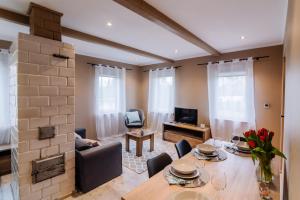 a living room with a table and chairs and a television at Domek na Podlasiu in Dubicze Cerkiewne