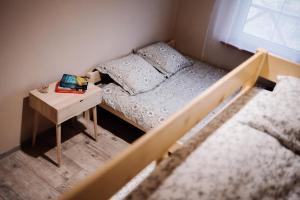 a small bedroom with a bed and a table with a laptop at Domek na Podlasiu in Dubicze Cerkiewne