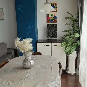 una mesa de comedor con un jarrón con flores. en ESS01256 Vivienda situada en la calle Mitxelena en Zarautz