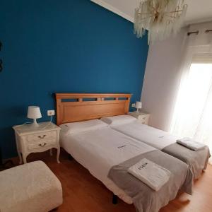 1 dormitorio con 2 camas y pared azul en ESS01256 Vivienda situada en la calle Mitxelena en Zarautz