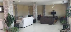 a living room with two couches and a tv at Hotel Sevilla Perote in Perote