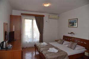 a hotel room with two beds and a window at Guest House Zec in Budva