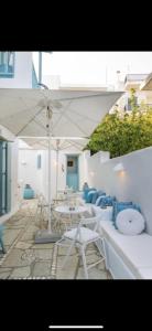 een groep tafels en stoelen onder een paraplu bij Studios Eleni II in Tinos Town