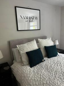 1 cama con almohadas y una foto en la pared en Entire Modern Apartment in Oban with Balcony, en Oban