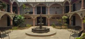 une cour avec une fontaine au milieu d'un bâtiment dans l'établissement Hotel Sevilla Perote, à Perote