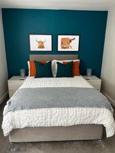 1 dormitorio con 1 cama grande y pared azul en Entire Modern Apartment in Oban with Balcony en Oban