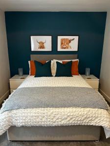 1 dormitorio con 1 cama grande y paredes azules en Entire Modern Apartment in Oban with Balcony, en Oban