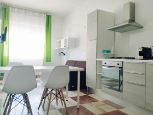 a kitchen with white cabinets and white stools at Thomas'home in Comiso