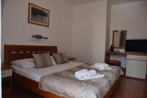 a bedroom with a bed with two towels on it at Guest House Zec in Budva