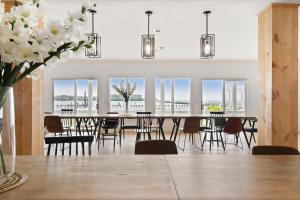 a dining room with a table and chairs and windows at 25 Bedrooms - Retreat Center Waterfront Renovated in Royal Oak