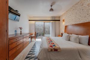 een slaapkamer met een bed, een bureau en een televisie bij Casona Las Tres Marías - Hotel Only adults in Mérida