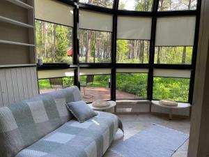 un soggiorno con divano e ampie finestre di Mugavustega majake mereäärses männikus. a Lohusalu