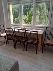 a dining room with a table and four chairs at Lipov lad in Bela Crkva