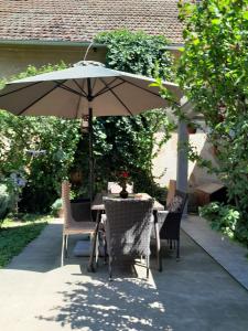 a table and chairs under an umbrella on a patio at Lipov lad in Bela Crkva