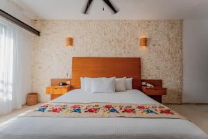 sypialnia z dużym łóżkiem z drewnianym zagłówkiem w obiekcie Casona Las Tres Marías - Hotel Only adults w mieście Mérida