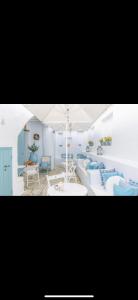 a living room with two beds and an umbrella at Studios Eleni II in Tinos