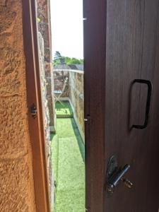 uma porta aberta com vista para um pátio verde em Château de Vassinhac chambres d'hôtes Collonges la rouge em Collonges