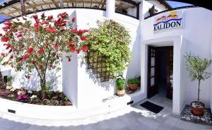a white building with flowers and plants on it at Kalidon beach Hotel in Kokkari