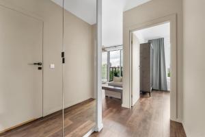 a hallway with white walls and a glass door at Galeria Północna Apt - 45m2, Parking, Balcony - by Rentujemy in Warsaw