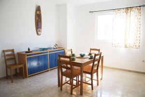 ein Esszimmer mit einem Tisch, Stühlen und einem Fenster in der Unterkunft Casa Arya in Cotillo