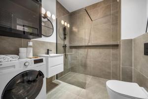 a bathroom with a washing machine and a toilet at Galeria Północna Apt - 45m2, Parking, Balcony - by Rentujemy in Warsaw