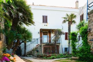 a white house with palm trees in front of it at La Terrazza sui Bastioni in Alghero