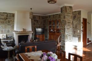 sala de estar con chimenea y mesa en Maria's Country House en Miranda do Douro