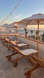una fila di sedie a sdraio con ombrellone in spiaggia di B&B felix a Porto Cesareo