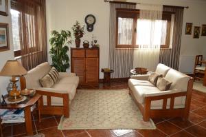 uma sala de estar com dois sofás e uma mesa em Maria's Country House em Miranda do Douro