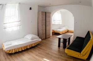 Cette chambre comprend deux lits, une chaise et une table. dans l'établissement Galeria PRL, à Borne Sulinowo