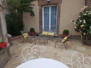 a patio with chairs and a table and a window at Le Clos Saint-Germain in Rugles
