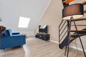 un salon avec un canapé bleu et une télévision dans l'établissement Luftig, leicht & lebensfroh - Loft - Wifi - TV, à Bielefeld