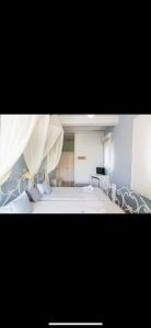 een grote slaapkamer met een groot bed met gordijnen bij Studios Eleni II in Tinos Town