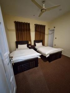 罕薩的住宿－Royal's Villa by Premiere Inn, Hunza，两张睡床,位于带喷雾器的房间