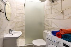 a bathroom with a white toilet and a sink at Teatrum in Liepāja